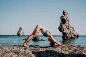 kvinna hav pilates. sportig Lycklig mitten åldrig kvinna praktiserande kondition på strand nära hav, leende aktiva kvinna Träning på yoga matta utanför, njuter friska livsstil, harmoni och meditation. foto