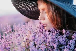 kvinna lavendel- fält. Lycklig sorglös kvinna i svart klänning och hatt med stor brätte lukta en blomning lavendel- på solnedgång. perfekt för inspirera och värma begrepp i resa och reslust. stänga upp foto