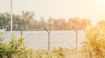 stor sol- station med blå solceller paneler inhägnad med gitter och hullingförsedda tråd. producerar rena energi från de Sol och minimerande de kol fotavtryck. foto