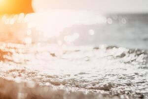 suddig gyllene hav på solnedgång. de Sol speglar och pärlar på de vågor med bokeh, belysande de gyllene hav. Semester rekreation begrepp. abstrakt nautisk sommar hav solnedgång natur bakgrund. foto