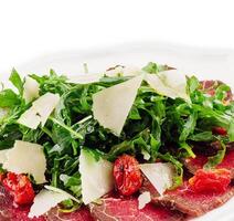 kött carpaccio med arugula och parmesan ost foto