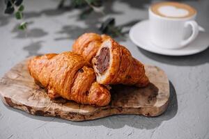 chokladfylld croissanter på trä- styrelse med kaffe foto