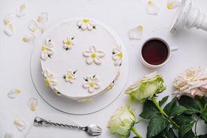 elegant vit blommig kaka med te miljö foto