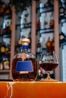 elegant brandy flaska och glas på bar disken foto