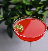 elegant röd cocktail med blommig garnering foto