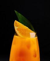 uppfriskande orange cocktail på svart bakgrund foto