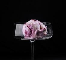 skopa av bär is grädde i elegant glas foto