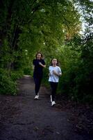 mor och dotter springa tillsammans längs en grön gränd foto