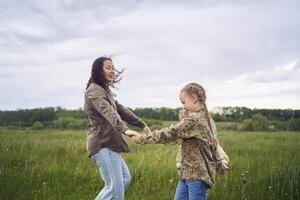 en mor och två systrar cirkel i de fält innehav händer foto