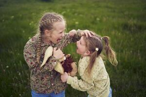 systrar bekämpa över en leksak kanin foto