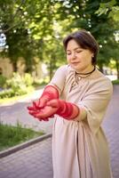 plus storlek kvinna i persika ludd klänning och röd genomskinlig handskar dans i de morgon- stad gator foto