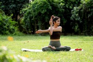 söt kvinna sexig Sammanträde på yoga matta och stretching henne vapen foto