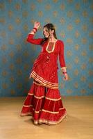 traditionell indisk kvinna i en röd salwar kostym Framställ i främre av kamera foto