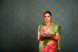 stock Foto av en varm fru i en saree och innehav en pooja tallrik på de diwali festival