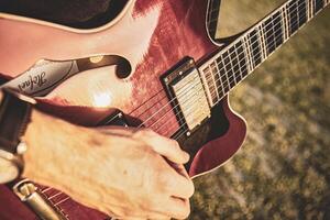 hand spelar gitarr i utomhus- detalj foto