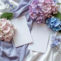 två tom anteckningsblock med blå och lila blommor på en lila silke bakgrund. foto