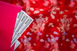 närbild av röd kuvert med pengar dollar eller ang pao. foto