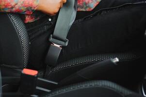 mörk brun hud afrikansk kvinna hand knäckning säkerhet bälte i de bil för bil olycka säkerhet begrepp foto
