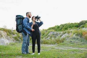 par njuter skön visningar på de berg, medan reser med ryggsäckar i de bergen under de sommar semester foto