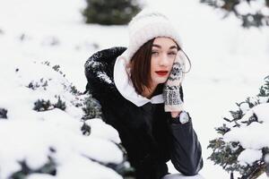 attraktiv ung kvinna i vinter- tid utomhus. snö, högtider och säsong begrepp. foto