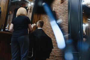 eleganta man Sammanträde barberare affär hårstylist frisör kvinna skärande hans hår porträtt stilig Lycklig ung skäggig caucasian kille få trendig frisyr attraktiv barberare flicka arbetssätt tjänande klient. foto