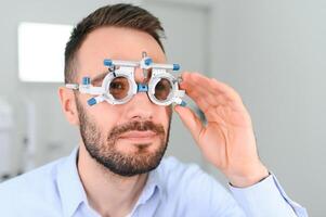 oftalmologi begrepp. manlig patient under öga syn undersökning i syn oftalmologiska korrektion klinik foto