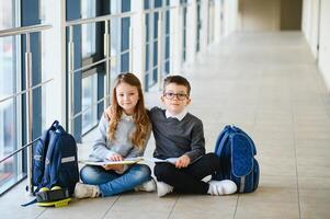 porträtt av leende skola barn i skola korridor med böcker foto