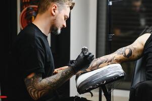 professionell tatuering konstnär arbetssätt i hans tatuering studio. foto