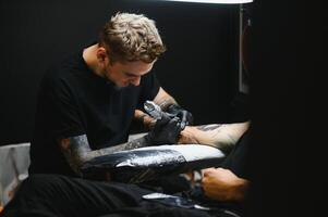 professionell tatuering konstnär arbetssätt i hans tatuering studio. foto