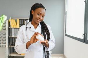 sjukvård och medicinsk begrepp - afrikansk läkare med blåsa förpackningar av piller. foto