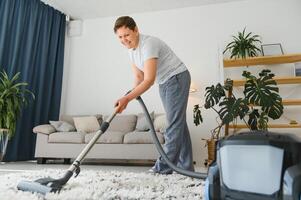 rengöring begrepp. kvinna rengöring matta med Vakuum rengöringsmedel. foto