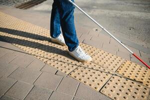 blind man gående på trottoar innehav pinne foto
