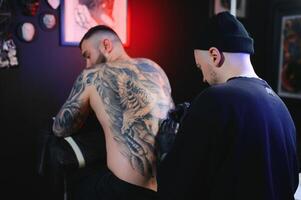 professionell tatuering konstnär gör en tatuering foto