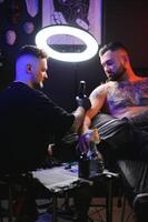 professionell tatuering konstnär gör en tatuering foto