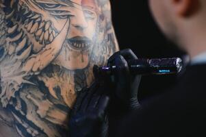 professionell tatuering konstnär gör en tatuering foto