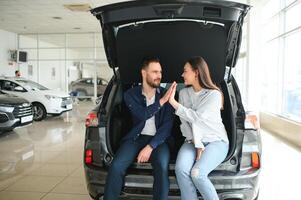Lycklig ung par väljer och uppköp en ny bil för de familj. på besök de återförsäljare foto