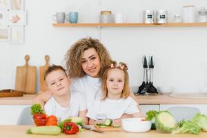 ung mor och henne två barn framställning vegetabiliska sallad foto