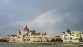 regnbåge över budapest - de ikoniska ungerska parlament byggnad Utsmyckad med en spektrum av ljus foto