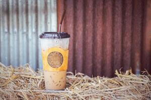 iced kaffe kopp placerad på en sugrör med en galvaniserad vägg i de Kafé affär. Plats för text foto