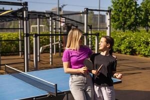 vuxen kvinna instruktör undervisning flicka spela tabell tennis foto