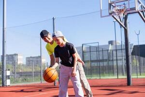 begrepp av sporter, hobbies och friska livsstil. ung människor spelar basketboll på lekplats utomhus foto