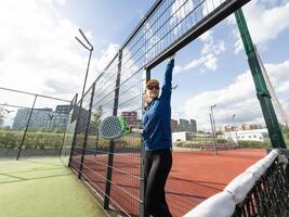 kvinna spelar padel i en grön gräs padel domstol Bakom de netto foto