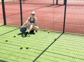 kvinna spelar padel i en gräs padel domstol inomhus- - ung sportig kvinna padel spelare slå boll med en racket foto