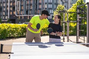 unge spelar tabell tennis utomhus- med familj foto