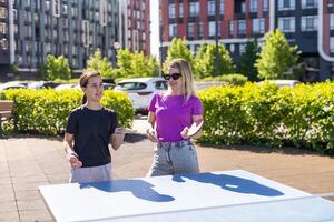 mor och dotter spela ping pong i parkera foto