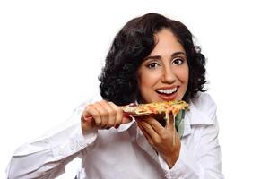 leende brunett modell med henne bit av pizza foto