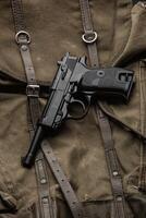 tysk årgång 9mm pistol från de andra värld krig. bakgrund från ett gammal duk militär ryggsäck. foto
