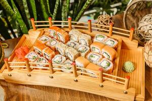 trä- bricka fylld med blandad sushi rullar foto