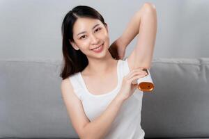 en skön kvinna är epilerande henne armhålor använder sig av ett ipl laser hår avlägsnande epilator enhet. foto