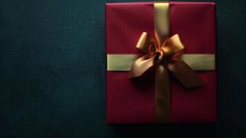 mörk röd gåva låda med elegant guld band på mörk bakgrund. hälsning gåva med kopia Plats för jul närvarande, Semester eller födelsedag foto